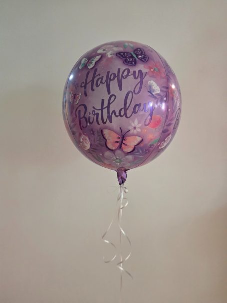 Lila Geburtstagsballon mit Schmetterlingen und „Happy Birthday“-Aufschrift.