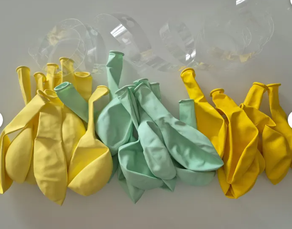 einzelne Luftballons in den Farben gelb und mint mit einem transparenten Lochband.